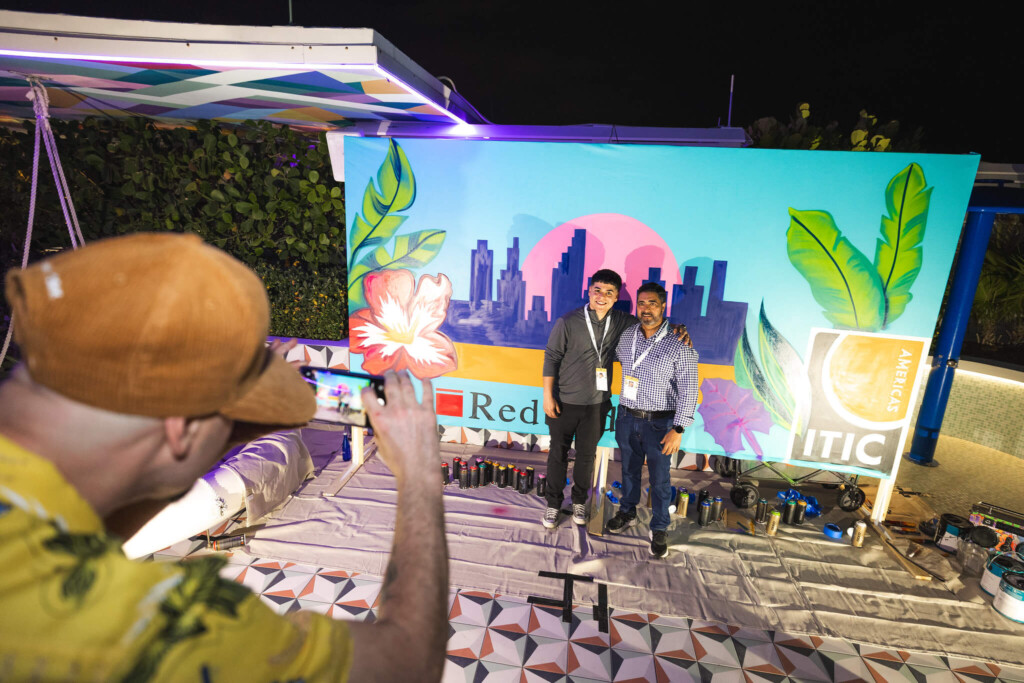 Attendees taking a photo in front of the backdrop